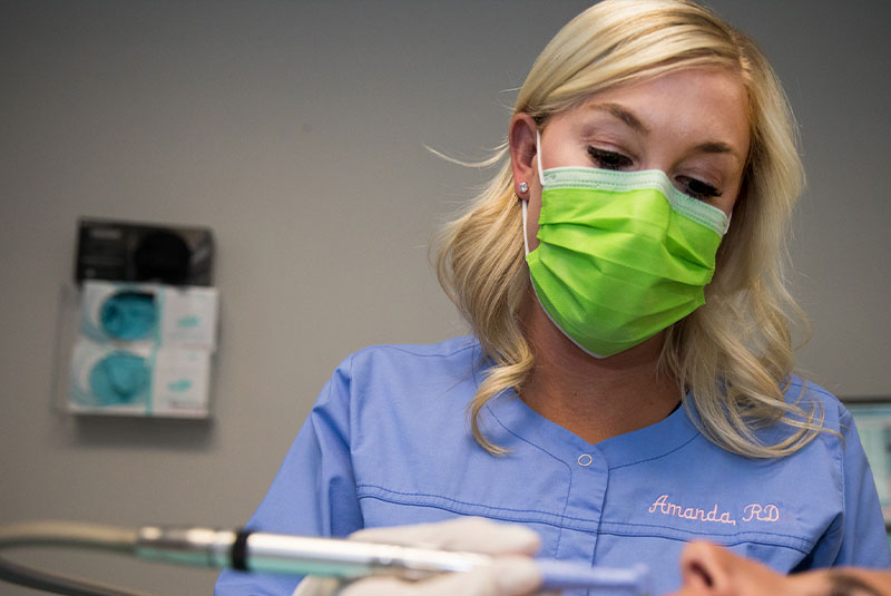 dentist with cleaning tool