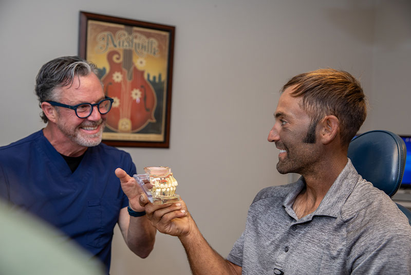 Dr. Given and patient looking at model of teeth