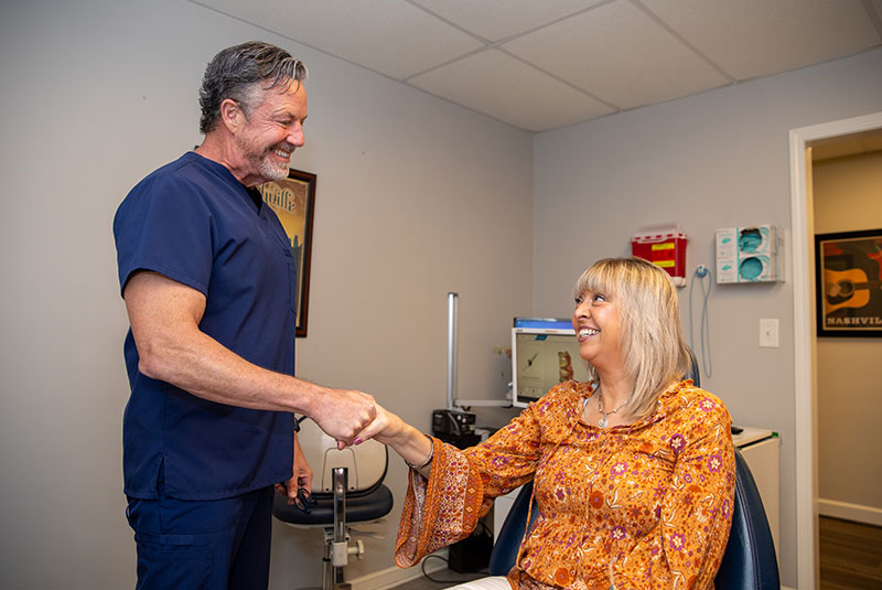 Dr given shaking patient hand after smile makeover consultation